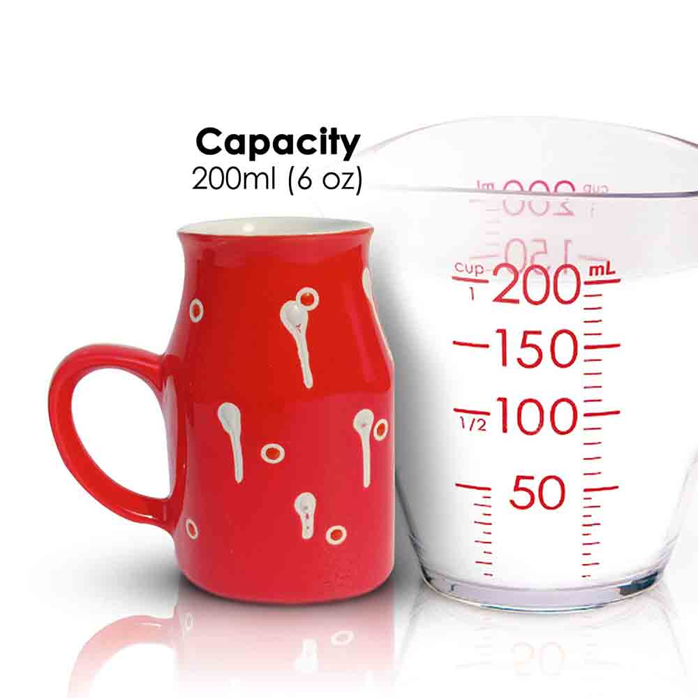 Red Coffee Mug 500ml with handpainted white drop design sitting on a kitchen counter.