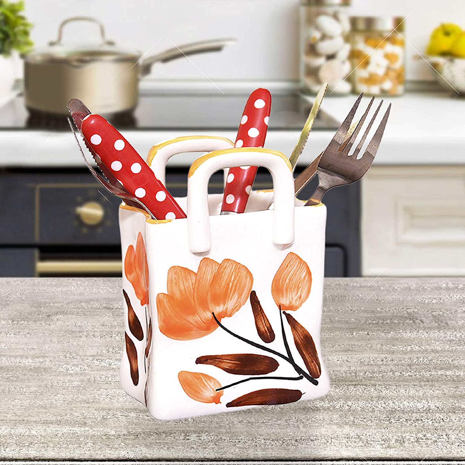 White ceramic cutlery holder featuring intricate handpainted floral design on kitchen countertop.