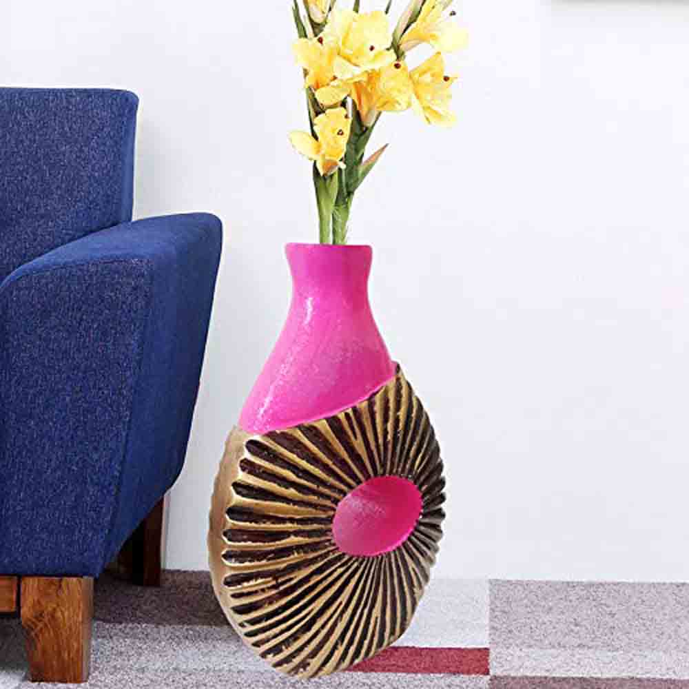 Golden and pink hand-painted vase with sun motif on kitchen counter beside fresh red roses.
