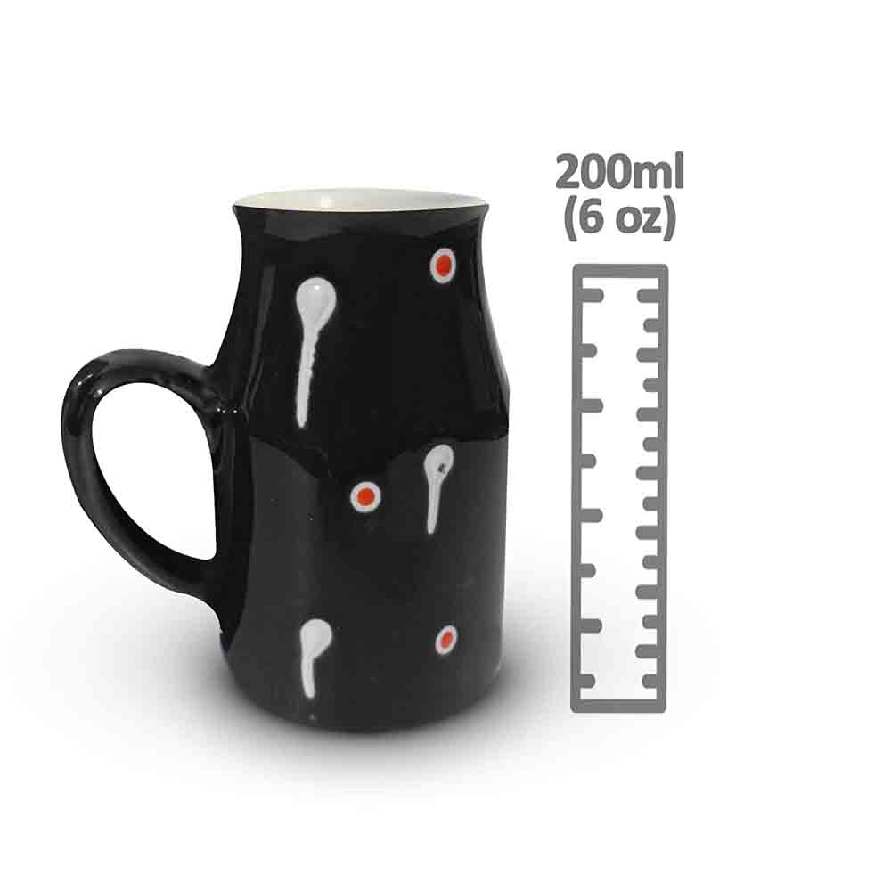 Black ceramic coffee mug with a capacity of 500ml showcasing the hand-painted white drop design on a table.