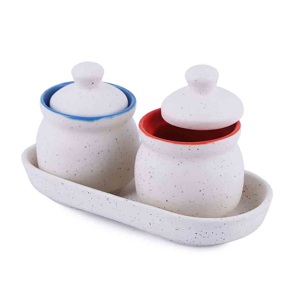 White Ceramic Jar with Lid Set displayed on kitchen counter next to spices and utensils.